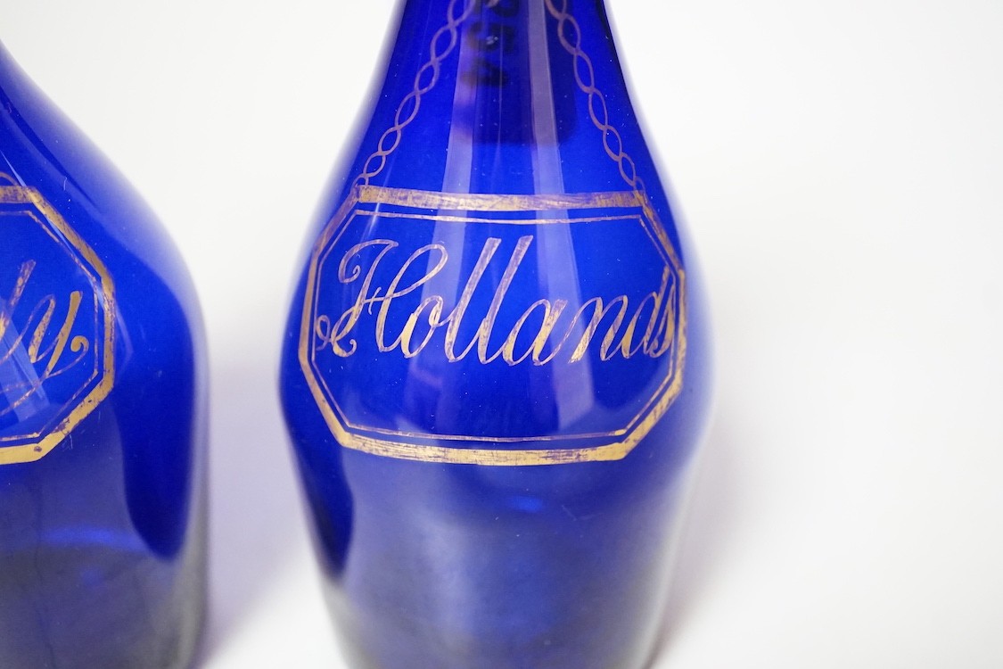 A pair of Regency blue glass decanters, labelled in gilt; Brandy and Hollands, 19cms high not including stoppers